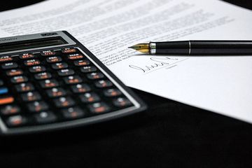 ducumento firmado al lado una calculadora